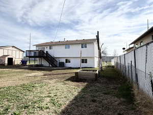 Back of house featuring a vegetable garden, a deck, and a patio area