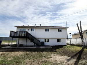 Rear view of house with a patio area, a wooden deck, and stucco siding