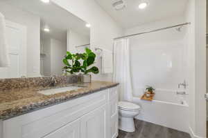 Primary Full bath with vanity, dark wood finished floors, shower / bath combo with shower curtain, and recessed lighting