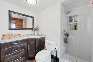 Full bathroom featuring vanity, a tile shower, and a textured ceiling