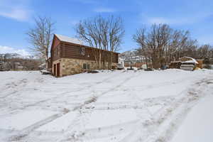 View of snow covered exterior with log siding and a mountain view