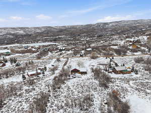 Snowy aerial view featuring a mountain view and a residential view