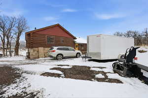 Snow covered property with log siding