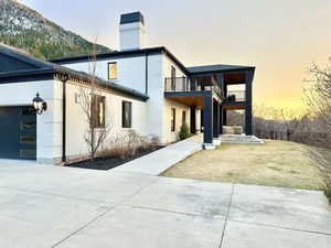 View of front of home with a chimney, brick siding, an attached garage, and a yard