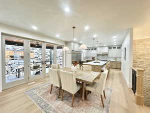 Dining area with french doors, light wood-type flooring, a textured ceiling, and recessed lighting