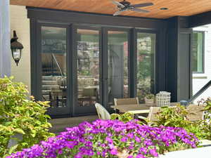 View of exterior entry with a ceiling fan and outdoor dining space