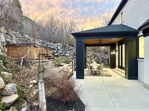 Patio terrace at dusk featuring a patio and a ceiling fan