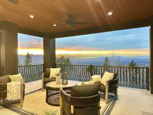 Balcony at dusk with ceiling fan, a patio, an outdoor living space, and a mountain view