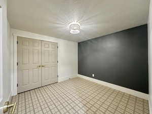 Unfurnished bedroom with a textured ceiling and a closet