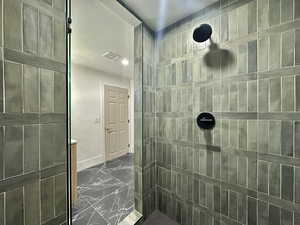 Full bathroom with a tile shower, dark marble finish flooring, recessed lighting, and a textured ceiling