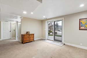 Entryway featuring a textured ceiling, carpet, and recessed lighting