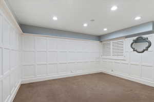 Empty room with a decorative wall and recessed lighting