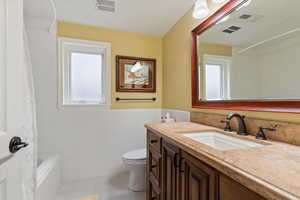 Full bath with vanity, tile walls, a wainscoted wall, shower / bath combo with shower curtain, and tile patterned floors