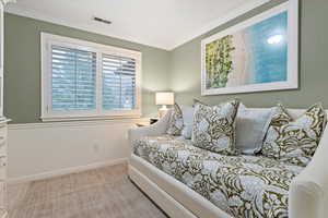 Bedroom featuring light carpet and ornamental molding