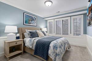 Bedroom featuring ornamental molding, carpet, and a textured ceiling
