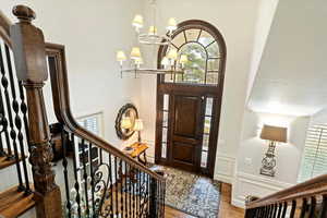 Foyer with suspended lighting, wood finished floors, and a decorative wall