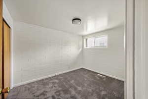 Spare room featuring dark carpet