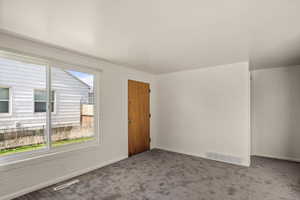Carpeted spare room featuring baseboards