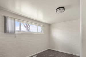 Spare room featuring dark colored carpet