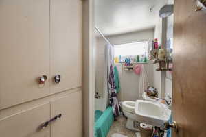 Full bath with shower / bathtub combination with curtain and light tile patterned flooring