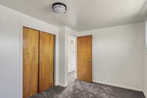 Unfurnished bedroom featuring a closet and carpet