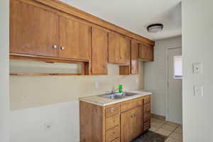 Kitchen featuring wood finish cabinets, light countertops, and light tile patterned flooring