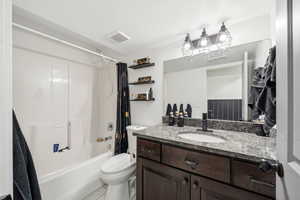 Bathroom featuring vanity, shower / tub combo, and light tile patterned flooring
