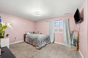 Bedroom with baseboards and light carpet