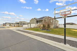 View of front facade with driveway, a residential view, and stucco siding