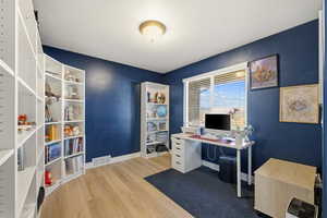 Office space with light wood-style flooring and baseboards