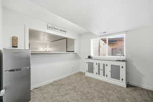 Interior space with freestanding refrigerator and carpet floors