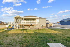 Back of house with a storage unit, a patio area, a deck, and stucco siding