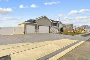 Ranch-style home featuring a gate, a garage, stucco siding, concrete driveway, and covered porch