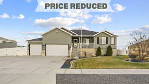 Single story home with an attached garage, stucco siding, a gate, concrete driveway, and covered porch