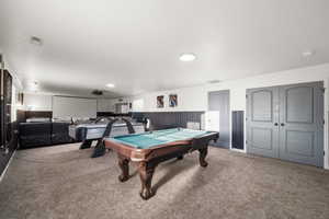 Game room featuring wainscoting, light carpet, pool table, and wood walls