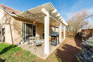 Fenced backyard featuring a pergola, area for grilling, and a patio area