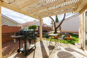 Fenced backyard featuring a patio area, a grill, and a pergola