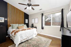 Bedroom featuring an accent wall and ceiling fan