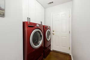 Laundry area with separate washer and dryer and cabinet space