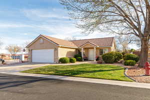 View of front of home featuring stucco siding, driveway, a garage, a tile roof, and a front lawn