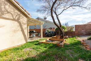 Fenced backyard featuring a pergola, a patio, and a vegetable garden