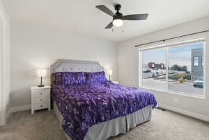 Primary bedroom with large window and ceiling fan