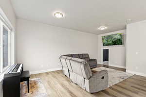 Large family room with wood-style flooring and a large window for tons of natural light