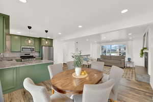 Dining space with light wood finished floors and recessed lighting