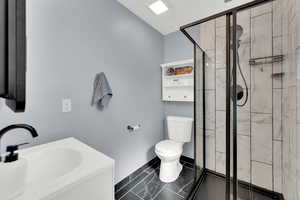 Newly remodeled primary Bathroom featuring a shower stall and vanity