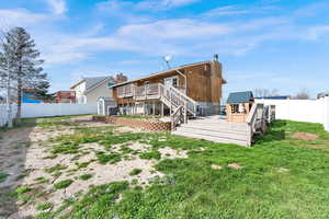 Back of property with a storage shed, patio, a wooden deck, and a fenced backyard
