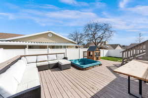 Wooden deck with a fully fenced (vinyl) backyard and an outdoor living space