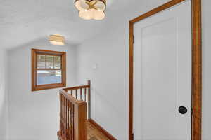 Hallway with parquet flooring and an upstairs landing