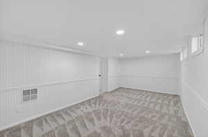 Finished below grade area with recessed lighting and light colored carpet