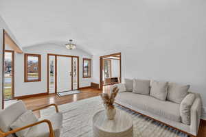 Living area with light wood-style floors and a barrel ceiling